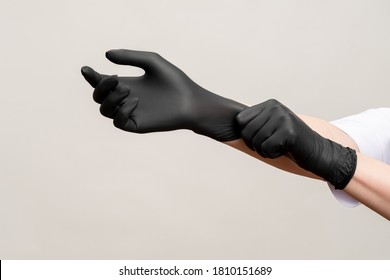 Chef hands. Kitchen hygiene. Woman wearing black latex gloves isolated on light copy space background. Professional culinary. Master class.
