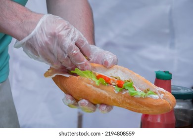 Chef Hands Making Fresh Submarine Hotdog Sandwiche At Summer Local Food Market - Close Up. Outdoor Cooking, Gastronomy, Street Food Concept
