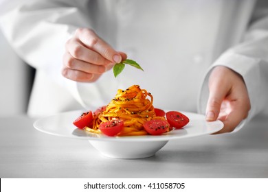 Chef hands preparing delicious cold pasta salad on the table closeup - Powered by Shutterstock