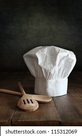 Chef Hat And Wooden Spoons On Wooden Table