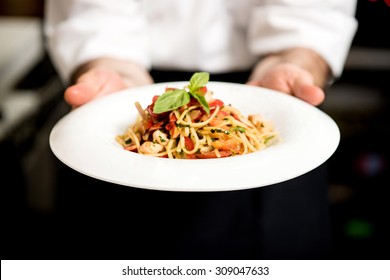 Chef holding hot spaghetti to serve in the restaurant
