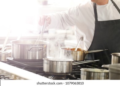 Chef In Hotel Or Restaurant Kitchen Cooking 
