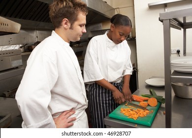 Chef Instructing Trainee In Restaurant Kitchen - Powered by Shutterstock