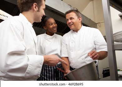 Chef Instructing Trainees In Restaurant Kitchen - Powered by Shutterstock