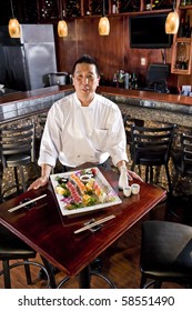 Chef In Japanese Restaurant With Sushi Platter