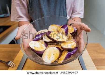 Chef at the kitchen preparing grilled eggplants with garlic