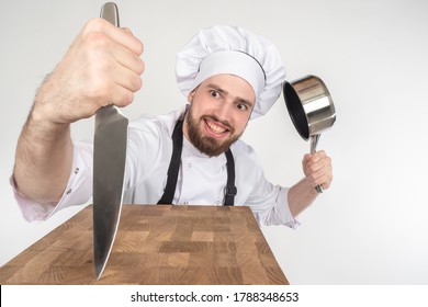 Chef Knife. Cook Is Showing Off His Knife. Satisfied Cook With Pan In His Hands. Cutting Board. Concept - Sale Of Knives For Chefs. Chef Recommended Knive. Inventory For Restaurant's Kitchen. Cafe