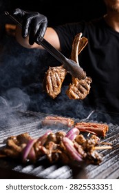 Chef Lifting Grilled Lamb Chops with Tongs