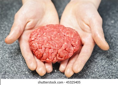 Chef making hamburger patty in kitchen with ground beef
