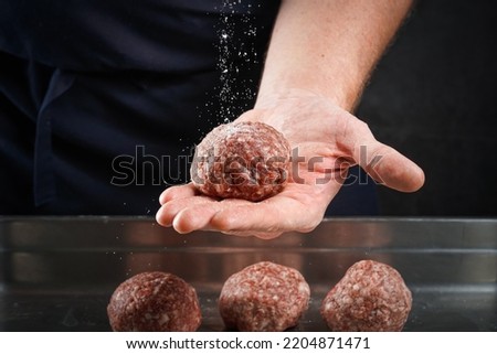 Chef making meat balls for smash burger in kitchen.