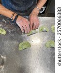 Chef making tortelli with herbs in a restaurant kitchen in Vigoleno, Italy, a traditional filled pasta similar to anolini, cappelletti, and agnolotti