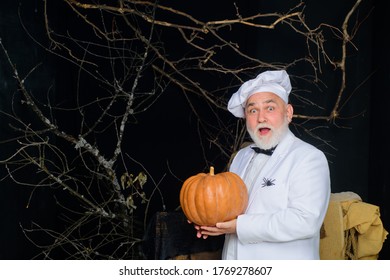 Chef Man With Pumpkin. Male Chef In Uniform With Pumpkin. Autumn Recipes Concept. Happy Halloween. Bearded Man Cook In Chef Hat With Pumpkin. Useful Vegetables.