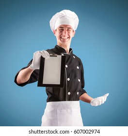 Chef with menu folder on a blue background. Modern chef concept.