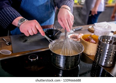 The chef mixes the sauce in a saucepan using the whisk. Master class in the kitchen. The process of cooking. Step by step. Tutorial. Close-up. - Shutterstock ID 1339666688