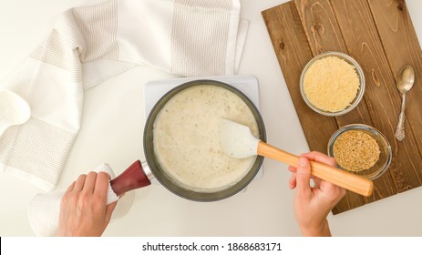 Chef Mixing Alfredo Sauce In Saucepan, Close Up View From Above