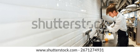Chef in a modern kitchen, focused and preparing a dish. Bright colors and spacious design with copy space. Ideal for culinary promotions and advertisements.