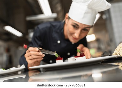 Chef Perfecting a Gourmet dessert adding green topping finishing dish, decorating meal in the end. Luxury hotel cooking concept image. - Powered by Shutterstock