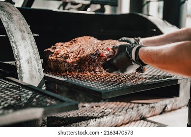 Chef pitmaster hand cooking grilled beef meat in BBQ smoker. - Shutterstock ID 2163470573