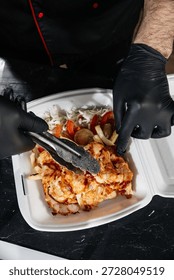 Chef Placing Meat into Container to Go	