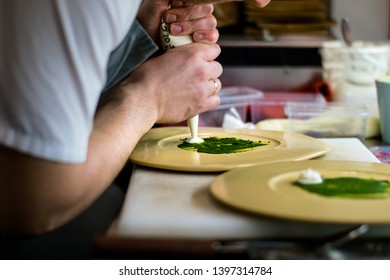 Chef Plating Food On A Dish At A Gourmet Restaurant