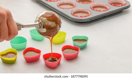 Chef pouring chocolate cake batter into  silicon heart-shaped mini molds. Chocolate cupcakes or chocolate muffins recipe, step by step preparation process - Powered by Shutterstock