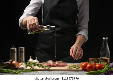 Chef pouring olive oil, three fresh raw steaks with meat on a dark background. Watering with oil before cooking, on a background with vegetables, tomatoes, hot pepper, onions, rosemary and basil - Powered by Shutterstock