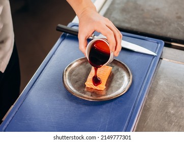 Chef Pouring Sauce On Raw Salmon