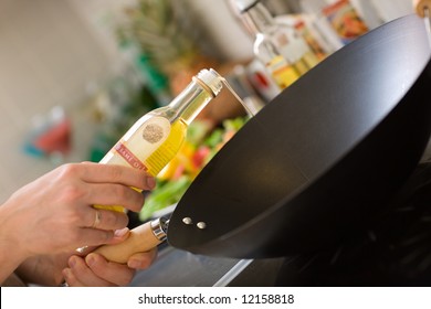 Chef Pouring Sesame Oil Into Wok Pan