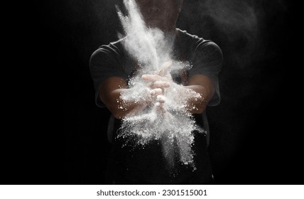 Chef prepare white flour dust for cooking bakery food. Elderly man Chef clap hand, white flour dust explode fly in air. Flour stop motion in air with freeze high speed shutter, black background - Powered by Shutterstock