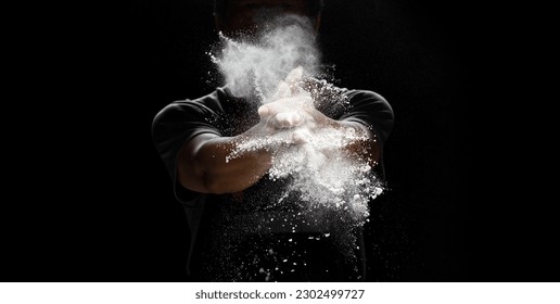 Chef prepare white flour dust for cooking bakery food. Elderly man Chef clap hand, white flour dust explode fly in air. Flour stop motion in air with freeze high speed shutter, black background - Powered by Shutterstock