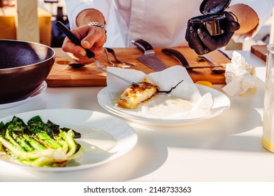 The chef prepares a fish fillet. Cooking and adding spices to seafood. Close-up. unrecognizable person - Powered by Shutterstock