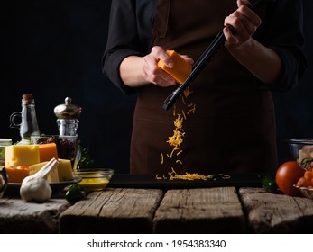 Chef prepares grated cheese for making Italian pizza, on the background of ingredients. Freezing in motion. Recipes, photos for illustrating cookbooks and recipes - Powered by Shutterstock