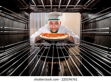 Chef prepares pizza in the oven, view from the inside of the oven. Cooking in the oven. - Powered by Shutterstock