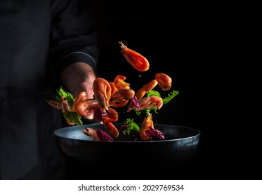 The Chef Prepares Shrimp With Herbs. Cooking Seafood, Healthy Vegetarian Food And Food On Dark Background. Free Advertising Space