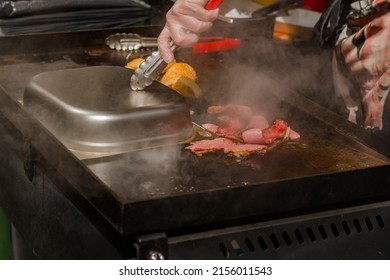 Chef Preparing Burger Buns, Bacon Slices On Grill At Summer Local Food Market - Close Up View. Outdoor Cooking, Gastronomy, Cookery, Street Food Concept