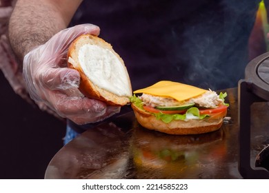 Chef Preparing Cheeseburger With Fish On Brazier At Summer Local Food Market - Close Up. Outdoor Cooking, Gastronomy And Street Food Concept