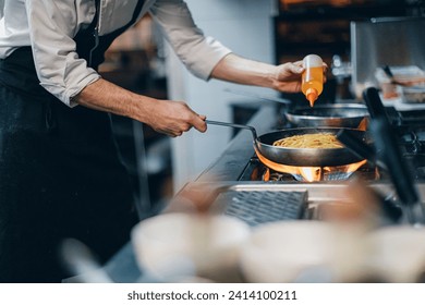 Chef preparing a dish in traditional italian restaurant kitchen - Powered by Shutterstock