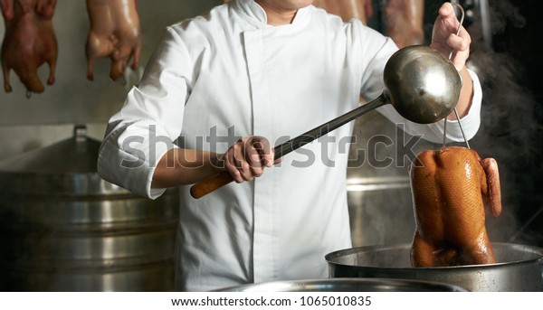 Chef preparing of\
Peking Roast Duck in the kitchen of restaurant. Peking Duck is a\
famous duck dish from\
Beijing