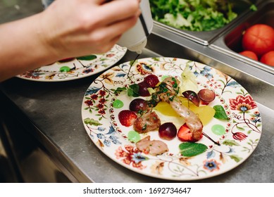 Chef Is Preparing A Salad In A Fancy Restaurant Kitchen And Putting Sauce On