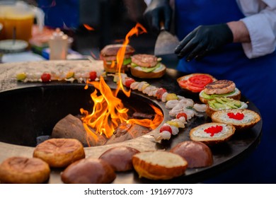 Chef Preparing Shrimp, Prawn Skewers And Burgers With Red Caviar, Avocado On Brazier With Hot Flame At Summer Local Food Market - Close Up. Outdoor Cooking, Seafood, Gastronomy, Street Food Concept