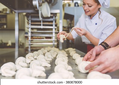 Chef preparing sweet croissant in the pastry shop laboratory. Industrial concept about food. Focus on the sweets - Powered by Shutterstock