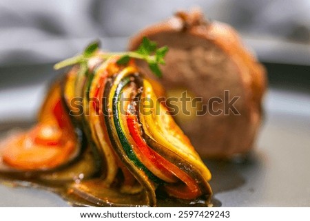 Chef preparing traditional Provençal vegetable dish Ratatouille with stuffed rolled meat on the grill. French food. Healthy eating. Delicious vegetable