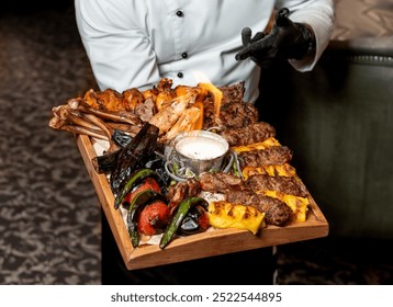 Chef presenting a lavish platter of mixed grilled meats with vegetables, perfect for a hearty feast at any gathering - Powered by Shutterstock