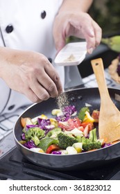 Chef Putting Pepper To The Pan For Cooking Vegetable