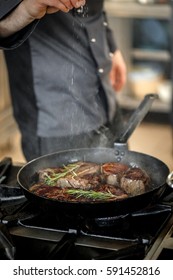 Chef Putting Salt For Cooking Meat In Restaurant Kitchen