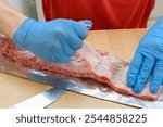 Chef removing the membrane from pork ribs before roasting, tasty barbecue ribs