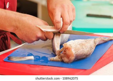 chef in restaurant slicing raw fish