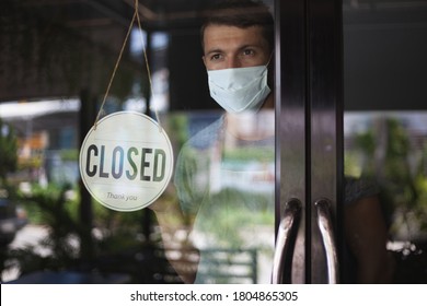 Chef In Safety Mask Hanging Up Sign Closed On Restaurant Door. 