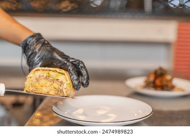 Chef serving a burrito on a plate, ready to take to the table. - Powered by Shutterstock