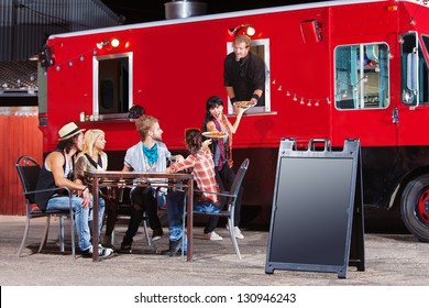 Chef serving food at mobile restaurant with blank sign - Powered by Shutterstock